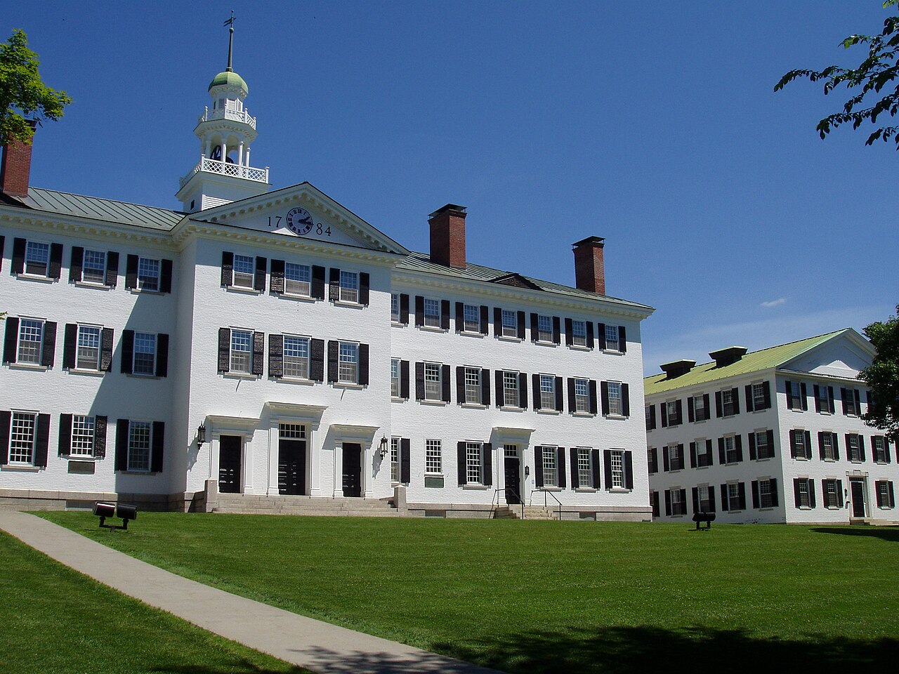 Dartmouth Hall’s white facade and cupola behind a green lawn in Hanover, New Hampshire